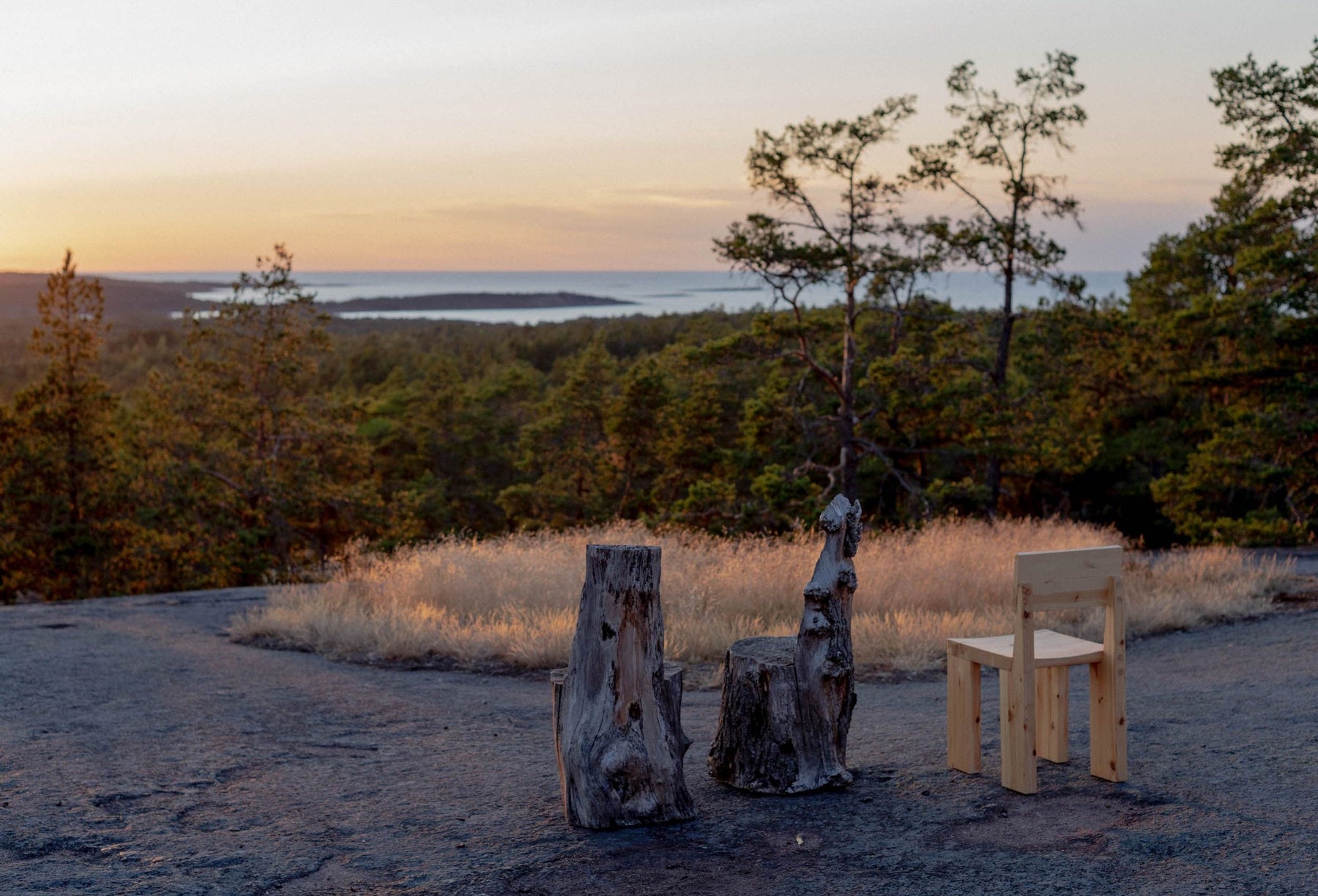 Vaarnii Finnish pine chair in a rocky forest landscape at sunset
