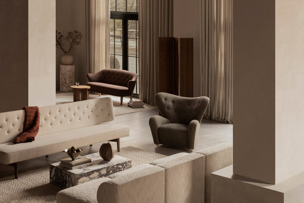 Audo Copenhagen classics including the Tired Man lounge chair and tufted seating in a warm neutral interior