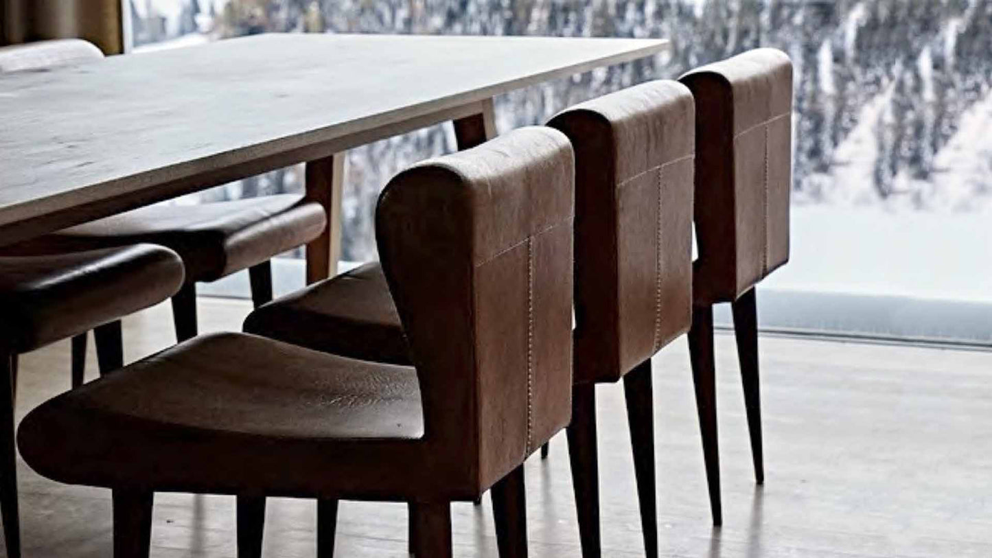 Sheep Chairs by Peter Zumthor beside a window overlooking snow