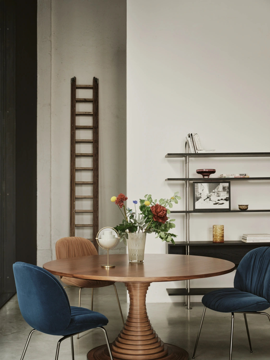 GUBI Keen Shelving System with enclosed box shelf behind a round dining table