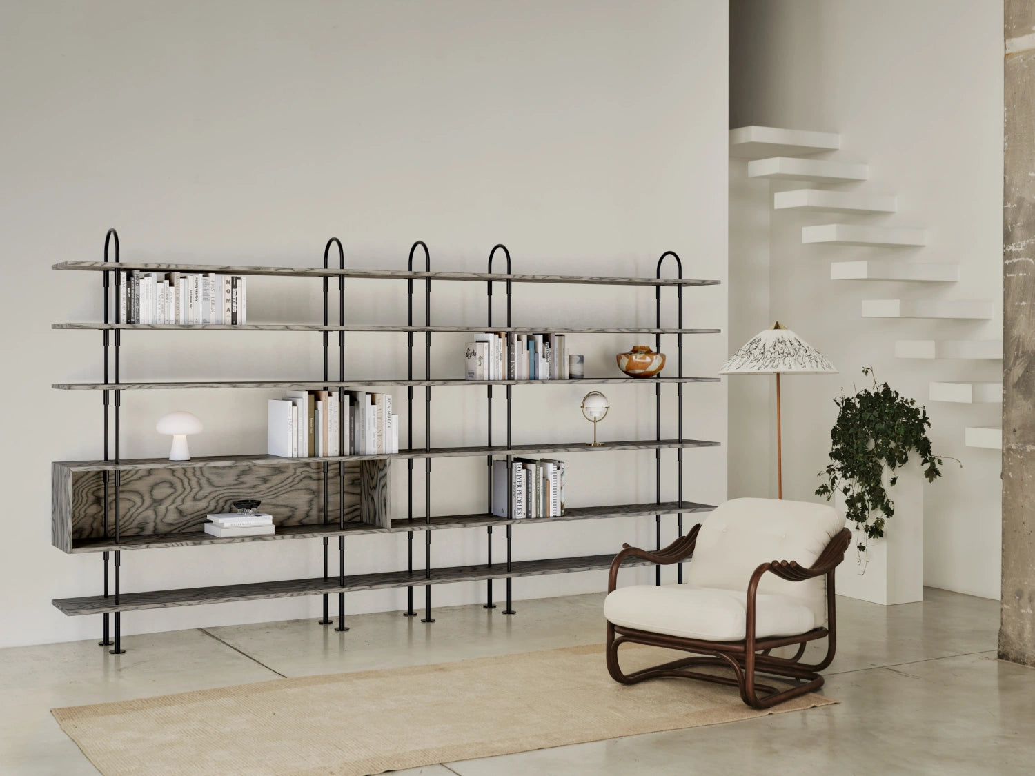 Expanded GUBI Keen Shelving System in black brass and ALPI veneer across a living room wall